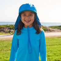 Kids Blue Legionnaire Sun Hat Upf 50 Size S Xl Girl Smiling Wearing Blue Hat on a Grassy Patch Sunpoplife